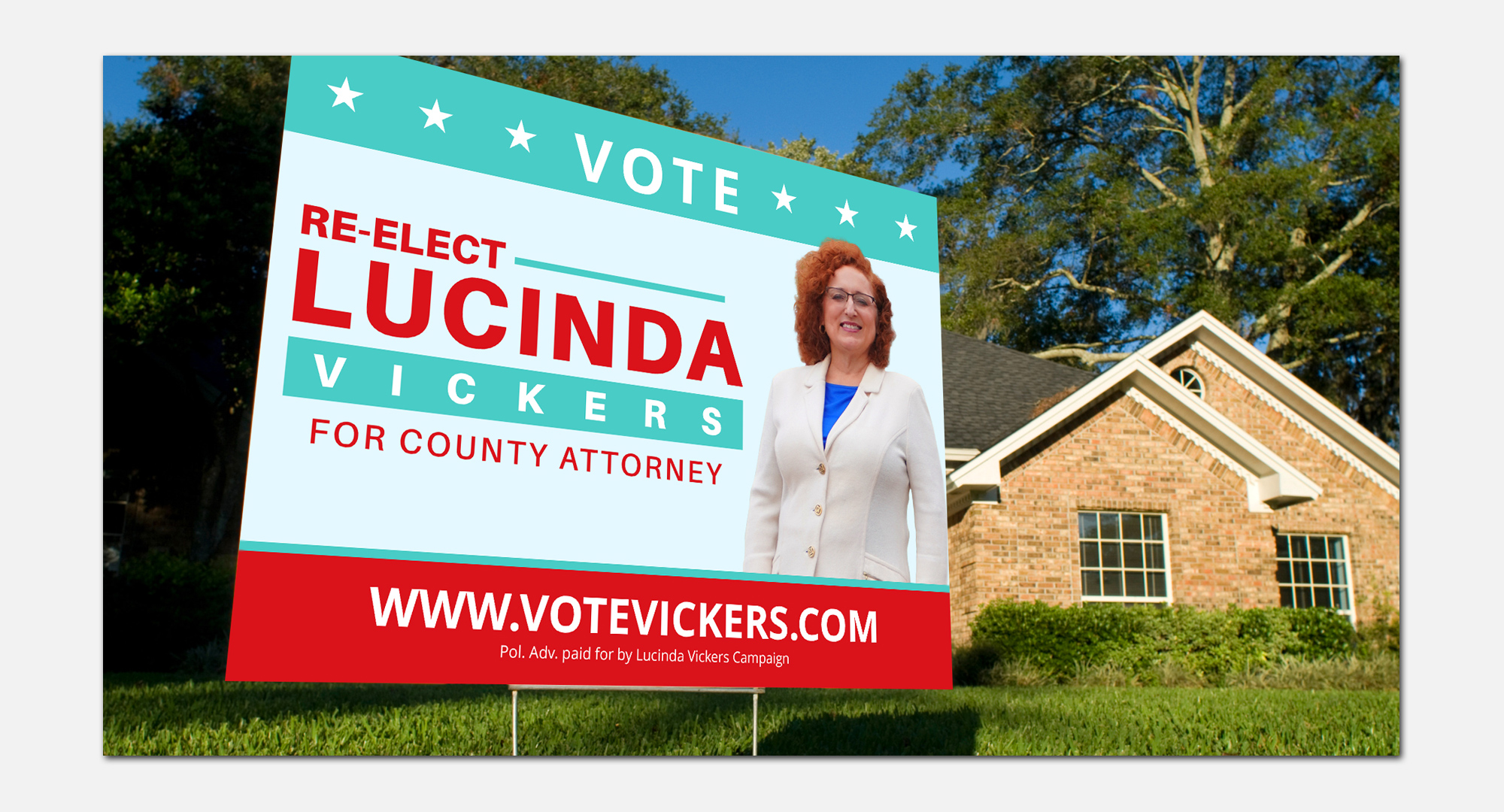 Large political yard sign promoting a county attorney candidate placed on a suburban lawn in front of a residential home. 