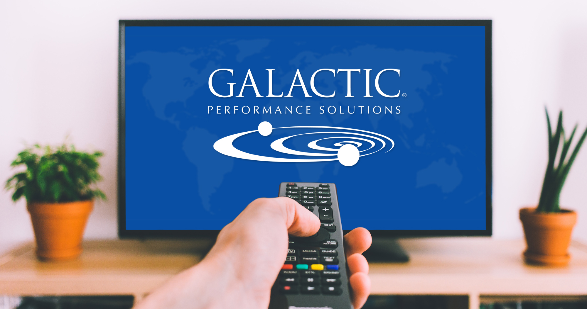 Hand holding a remote control pointed at a television displaying the Galactic Performance Solutions logo on screen for an educational B2B motion graphics video asset. 